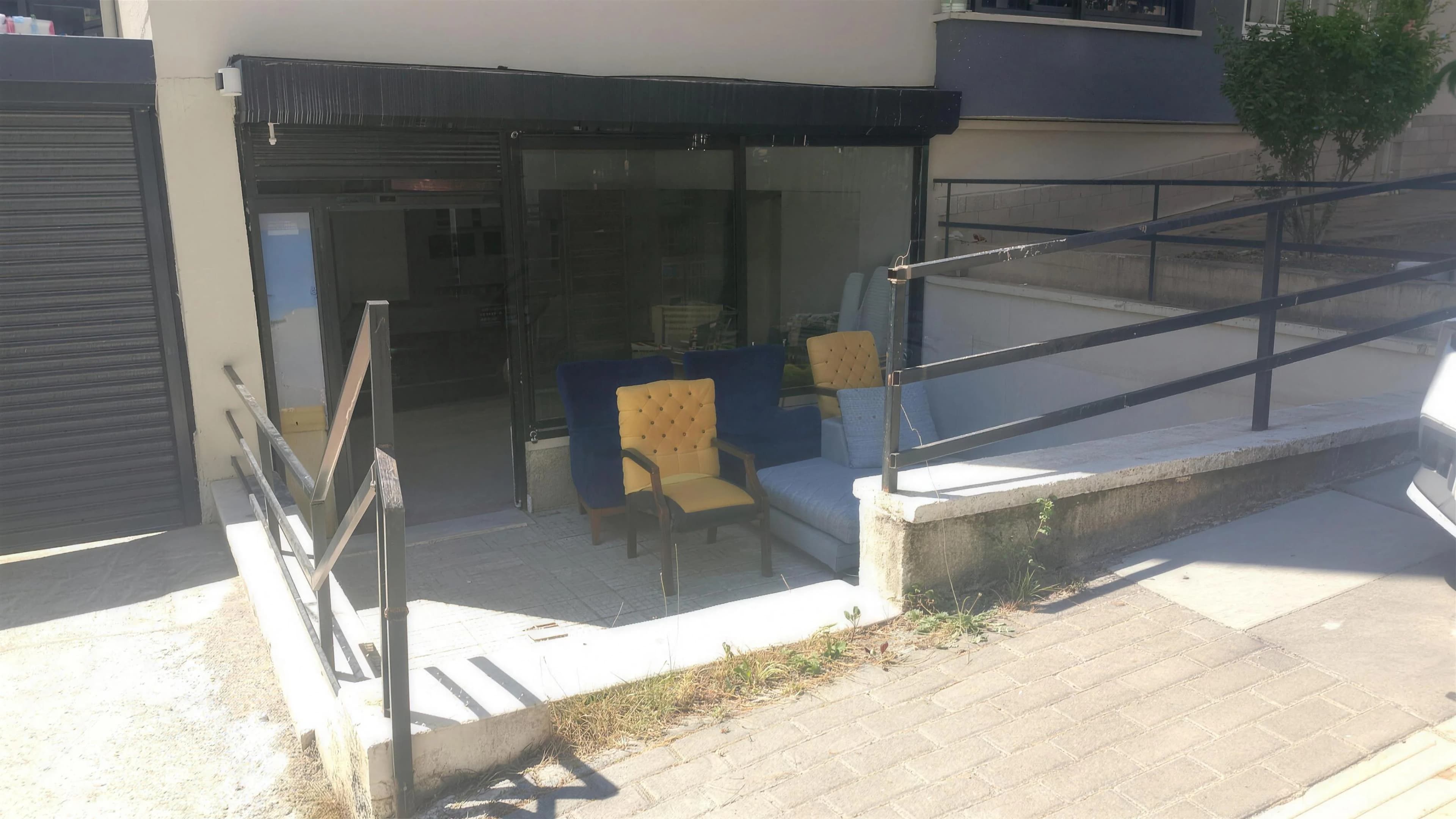 Sokaktan görülen Emek Döşeme atölyesi ve önündeki koltuklar